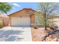 Tan single-story home featuring a two-car garage and desert landscaping at 41373 W Coltin Way, Maricopa, AZ 85138