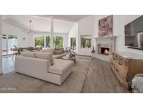 Inviting living room featuring a fireplace, vaulted ceilings, and seamless access to outdoor views at 8719 E San Marino Dr, Scottsdale, AZ 85258