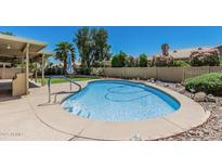 Backyard features a refreshing private pool with a concrete surround and rock landscaping at 8911 E Sutton Dr, Scottsdale, AZ 85260