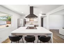 Bright kitchen with stainless steel appliances, white cabinets, and an island with seating at 1017 E Diana Ave, Phoenix, AZ 85020