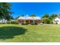 Charming brick home featuring a well-manicured lawn and a bright yellow front door at 16 W Colter St, Phoenix, AZ 85013
