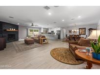 Spacious living room featuring a fireplace, modern lighting, and an open floor plan leading to the kitchen and dining area at 1744 E Huber St, Mesa, AZ 85203