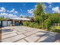 Paver driveway with lush plantings and a blue exterior at 2219 W Catalina Dr, Phoenix, AZ 85015