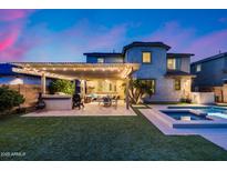 Entertainer's backyard with a large covered patio, built-in grill, and sparkling pool/spa, perfect for outdoor gatherings and relaxation at 3933 E Alfalfa Dr, Gilbert, AZ 85298