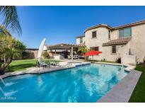Lovely pool with attached hot tub, patio area, and well-kept lawn and landscaping at 3933 E Alfalfa Dr, Gilbert, AZ 85298