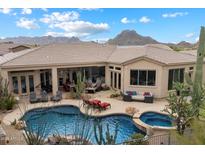 Inviting backyard pool and spa with desert landscaping and mountain views, perfect for outdoor living at 11448 E Blue Sky Dr, Scottsdale, AZ 85262