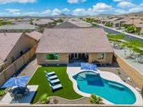 Aerial view of the house with backyard pool, patio furniture, manicured lawn, and privacy wall at 15663 S 183Rd Dr, Goodyear, AZ 85338