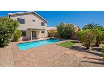A private backyard pool is surrounded by a brick patio and lush landscaping, perfect for outdoor entertaining at 22420 N 20Th Pl, Phoenix, AZ 85024