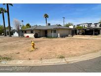 Charming single-story home with a carport in a sunny neighborhood, with a yellow fire hydrant in the front yard at 402 W Flower St, Phoenix, AZ 85013