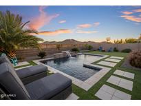 Resort-style backyard pool with water feature, mountain views, basketball hoop, and lounge seating at 537 E Balao Dr, Phoenix, AZ 85085