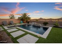 Beautiful backyard pool with mountain views, waterfall feature, and low-maintenance artificial turf at 537 E Balao Dr, Phoenix, AZ 85085