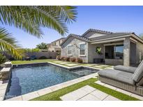 Serene backyard oasis with a sparkling pool, modern pavers, and a comfortable lounge area at 537 E Balao Dr, Phoenix, AZ 85085