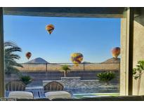 Stunning view from home featuring hot air balloons over desert landscape and pool at 537 E Balao Dr, Phoenix, AZ 85085