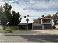 Charming home featuring mature landscaping, palm trees, 2-car garage, and a private second story balcony at 5751 E Ludlow Dr, Scottsdale, AZ 85254