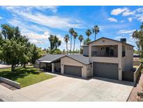 A beautiful two-story home with three-car garage, an upstairs balcony, and mature landscaping at 5751 E Ludlow Dr, Scottsdale, AZ 85254