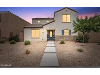 Charming two-story home featuring stone accents, low-maintenance landscaping, and a inviting blue front door at 8043 W Albeniz Pl, Phoenix, AZ 85043