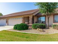 Charming home boasts a manicured front yard with lush landscaping and inviting stone accents on the porch at 11360 E Keats Ave # 70, Mesa, AZ 85209