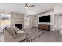 Inviting living room boasts a fireplace, ceiling fan and neutral decor throughout the home at 19202 N 14Th St, Phoenix, AZ 85024