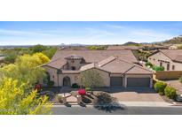 Stunning view of a luxurious home featuring a three car garage, beautiful tile roof, and colorful landscaping at 2304 N Steele Cir, Mesa, AZ 85207
