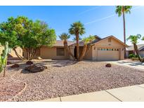 Charming single-story home featuring a two-car garage, desert landscaping, and mature palm trees at 2757 Leisure World --, Mesa, AZ 85206