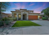 Beautiful stucco two-story home featuring a two-car garage and a well-manicured yard under a stunning sky at 29706 N 127Th Ln, Peoria, AZ 85383