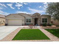 Charming single-story home with stone accents, manicured landscaping, and a well-maintained lawn at 30213 W Fairmount Ave, Buckeye, AZ 85396