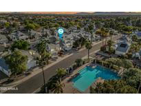 An aerial view showcases a well-maintained community, with a refreshing pool and lush palm trees at 3365 W Thude Dr, Chandler, AZ 85226