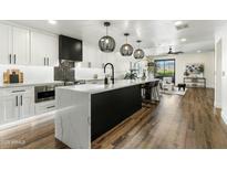 Open kitchen with island, pendant lights, stainless appliances, and a view into the living space at 36601 N Mule Train Rd # D1, Carefree, AZ 85377