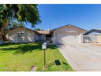 Charming single-story home featuring a well-maintained lawn, mature tree, and a two-car garage at 4716 W Hayward Ave, Glendale, AZ 85301