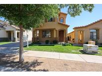 Charming tan two-story home with a well-maintained lawn, sidewalk, and mature landscaping for enhanced curb appeal at 5323 E Hopi Ave, Mesa, AZ 85206