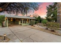 Charming home exterior with a spacious driveway and well-maintained landscaping at sunset at 7813 N 17Th Dr, Phoenix, AZ 85021