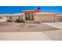 Inviting front yard featuring desert landscaping, charming curb appeal, and an American flag at 8037 E Navarro Ave, Mesa, AZ 85209