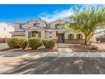 Charming two-story home with neutral stucco, stone accents, groomed bushes and mature tree at 1779 E Kaibab Dr, Chandler, AZ 85249