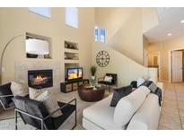 Inviting living room featuring a fireplace, high ceilings, and comfortable seating arrangement at 19550 N Grayhawk Dr # 1049, Scottsdale, AZ 85255