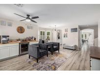 Open living room featuring a wet bar, modern light fixture, and neutral color palette at 3551 E Mead Dr, Gilbert, AZ 85298