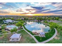 Scenic aerial view of the community lake, walking paths, pool and picnic areas at sunset at 4615 E Calistoga Dr, Gilbert, AZ 85297