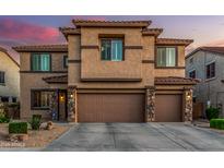 Inviting two-story home featuring a three-car garage and a landscaped front yard at 9113 W White Feather Ln, Peoria, AZ 85383