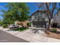 Two-story gray home featuring well-maintained landscaping, a spacious driveway, and a two-car garage at 13434 W Rovey Ave, Litchfield Park, AZ 85340