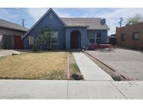 Charming blue home with drought-tolerant landscaping and red front door creates curb appeal at 1629 E Garfield St, Phoenix, AZ 85006