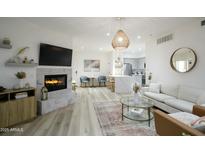 Bright living room with a fireplace, open floor plan, and modern decor at 1701 E Colter St # 488, Phoenix, AZ 85016