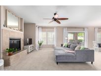 Cozy living room featuring a fireplace, ceiling fan, and sliding glass doors to the patio at 19700 N 76Th St # 1151, Scottsdale, AZ 85255