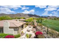 Inviting backyard with lush landscaping, desert plants, comfortable seating areas, and a scenic golf course view at 42109 N Astoria Way, Anthem, AZ 85086