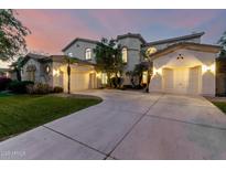Stunning front exterior featuring a large driveway leading to three garages and beautiful desert landscaping at 4494 E Reins Rd, Gilbert, AZ 85297
