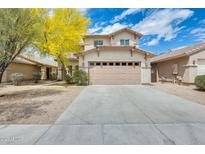 Two-story home with a large driveway and an attached two-car garage with a beige exterior at 6830 W Desert Ln, Laveen, AZ 85339