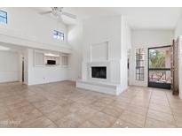Bright living room featuring a fireplace, tile floors, and an open layout connecting to the kitchen at 7800 E Lincoln Dr # 2092, Scottsdale, AZ 85250