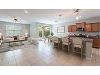 Open-concept living space with tile flooring connecting the kitchen, dining, and living areas at 18801 W Yucatan Dr, Surprise, AZ 85388