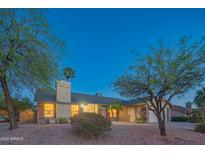 Dusk view of a well-lit single-story home featuring desert landscaping and inviting curb appeal at 11447 N 109Th St, Scottsdale, AZ 85259