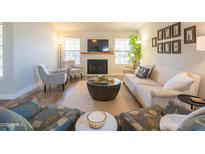 Bright living room featuring a cozy fireplace, modern furniture, and plenty of natural light at 11447 N 109Th St, Scottsdale, AZ 85259