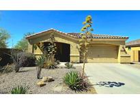 Charming home featuring a well-maintained yard with desert landscaping and a spacious two-car garage and tile roof at 18436 W Shasta St, Goodyear, AZ 85338