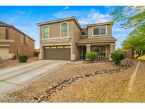 Two-story home with a neutral color scheme, a two-car garage, and low-maintenance desert landscaping at 21033 N Alexis Ave, Maricopa, AZ 85138
